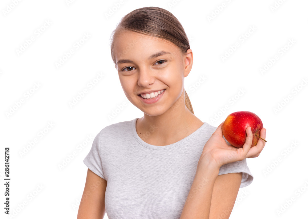 Portrait of beautiful young teen girl holding fresh red apple, isolated on white background. Smiling pretty child with healthy raw vegetables in hands. Organic natural healthy food produce. Portrait of beautiful young teen girl holding fresh red apple, isolated on white background. Smiling pretty child with healthy raw vegetables in hands. Organic natural healthy food produce.