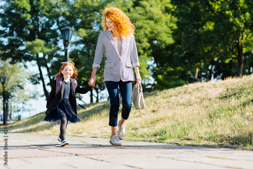 Fototapeta premium Amazing young woman walking with her daughter