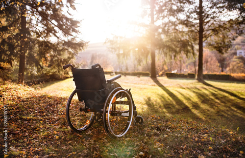 Empty wheelchair on a grass in park at sunset. © Halfpoint