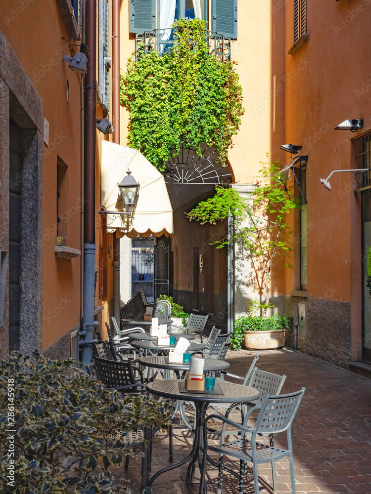 bright alley with outdoor table, como - Italy