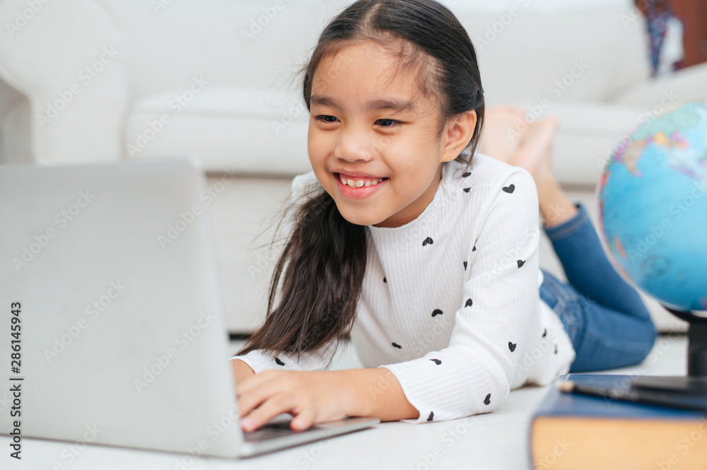 Happy Asian girl using laptop computer, concept for kid's art and home school. Happy Asian girl using laptop computer, concept for kid's art and home school.