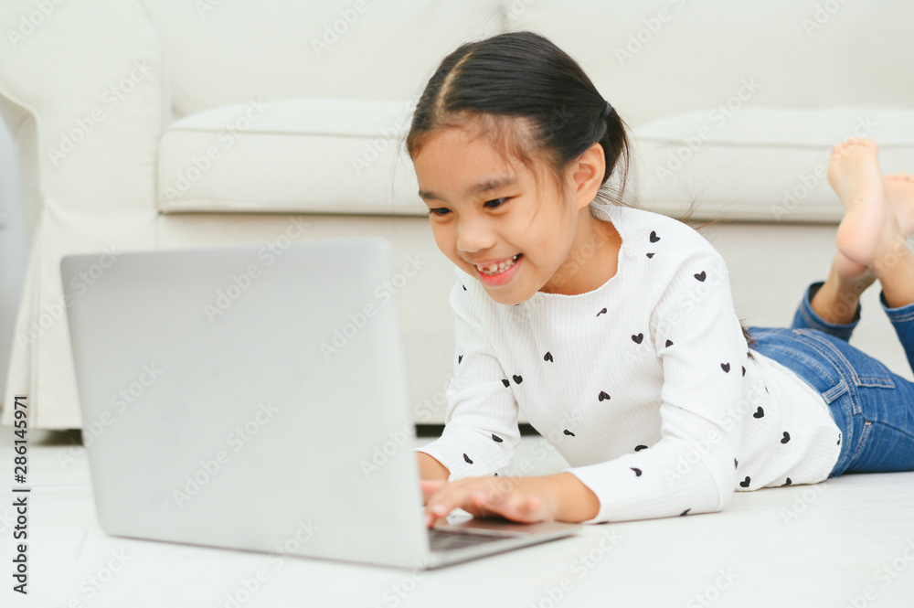 Happy Asian girl using laptop computer, concept for kid's art and home school. Happy Asian girl using laptop computer, concept for kid's art and home school.