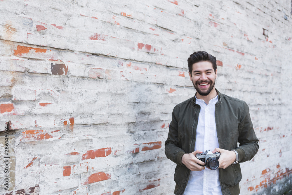 Portrait of laughing young man with camera