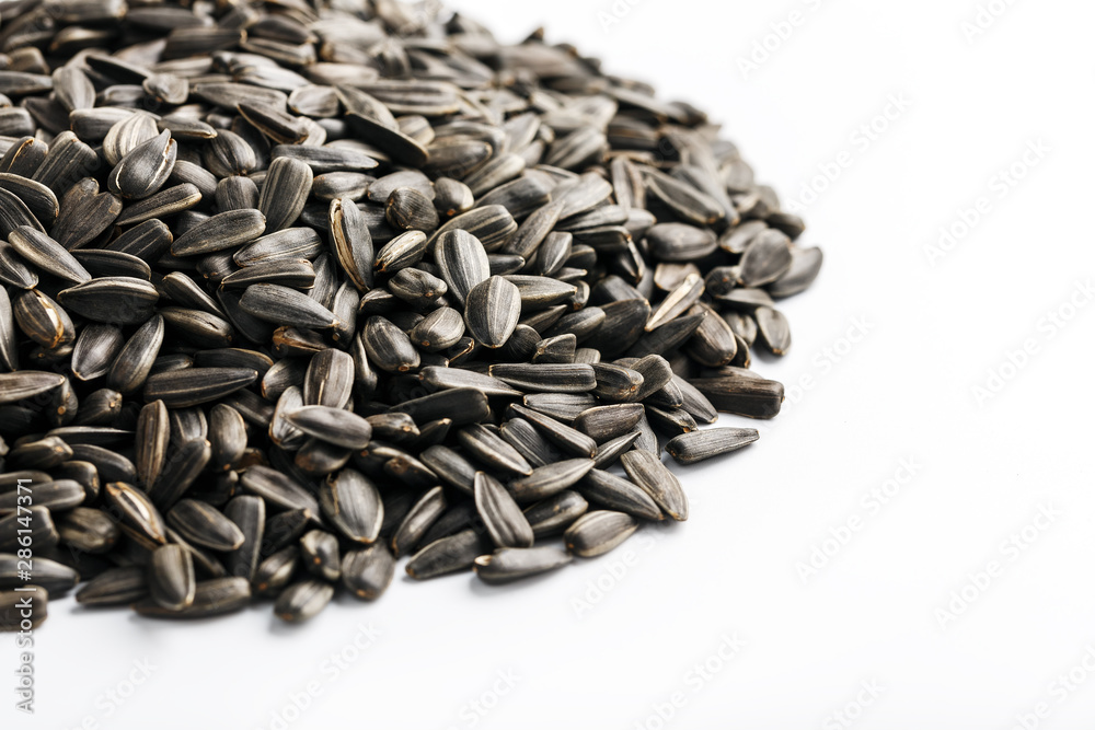Seeds in a black shell are a bunch on a white background. In full screen Seeds in a black shell are a bunch on a white background. In full screen