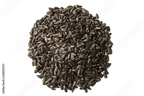 Seeds in a black shell are a bunch on a white background. In full screen