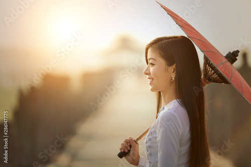 The beautiful woman Myanmar wearing traditional suit on during sunrise at ubien brige ,Mandalay Myanmar photo