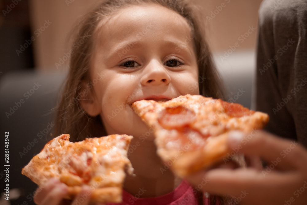 father feeding his cute daughter with pizza father feeding his cute daughter with pizza