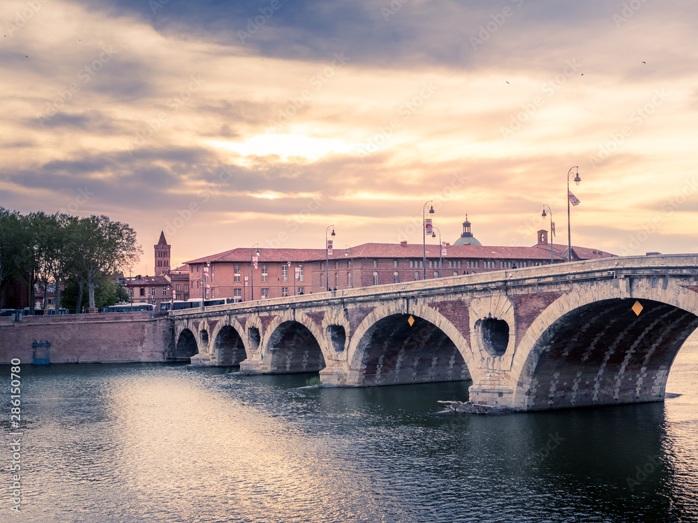 Atardecer en la ciudad de Toulousse, Francia, con el puente sobre el rio Garona y las tipicas casa de ladrillo rojo.