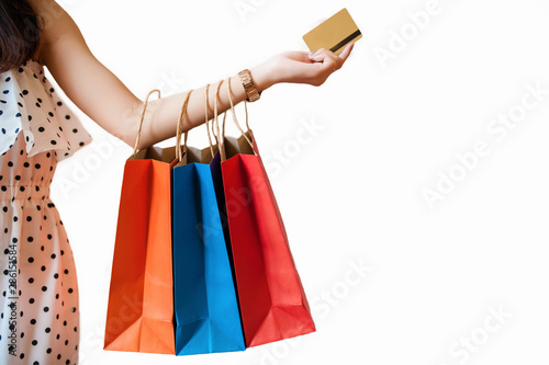 A girl holding a credit card with a colorful paper bag hanging her arms and have a white background.