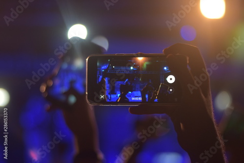 A boy making video at concert.