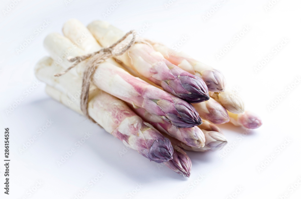 Raw white Asparagus with violet head as bunch on white background with copy space - isolated Raw white Asparagus with violet head as bunch on white background with copy space - isolated