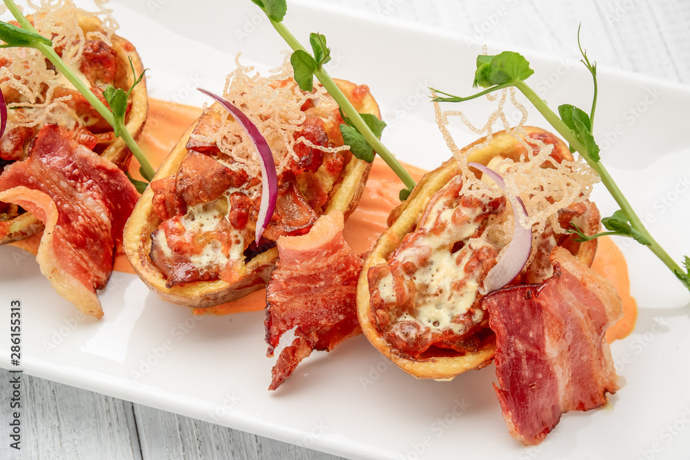 Potato skin with bacon and cheese, tomato sauce Potato skin with bacon and cheese, tomato sauce