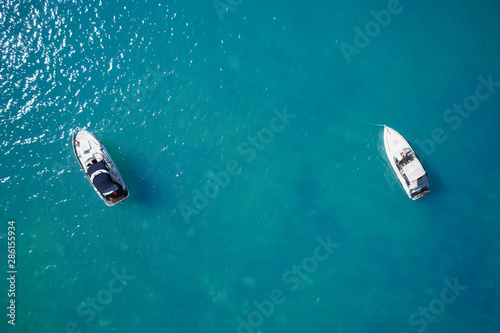 white yachts in a lagoon on blue water top view © Berg