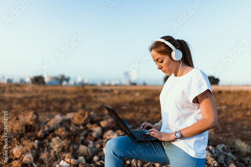 Foto Young woman with her laptop communicates with antennas