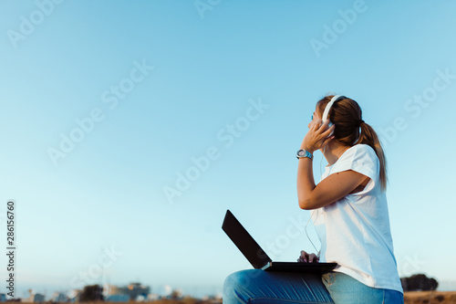 Fotografía Young woman with her laptop listened external communications