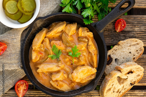 Fotografie Chicken fricassee with pickles in white sauce with tomatoes