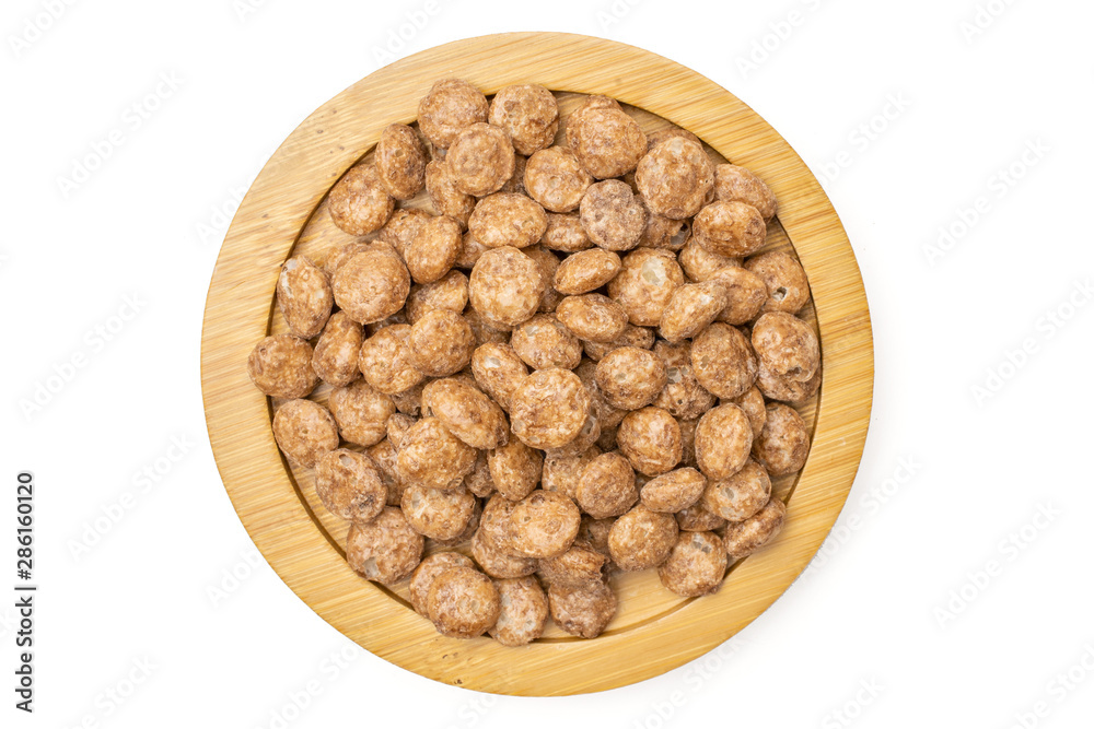 Lot of whole chocolate ball breakfast cereals on bamboo plate flatlay isolated on white background