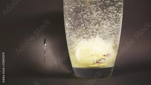 Ball form bath salt with interesting pattern drop slow motion in vase of water