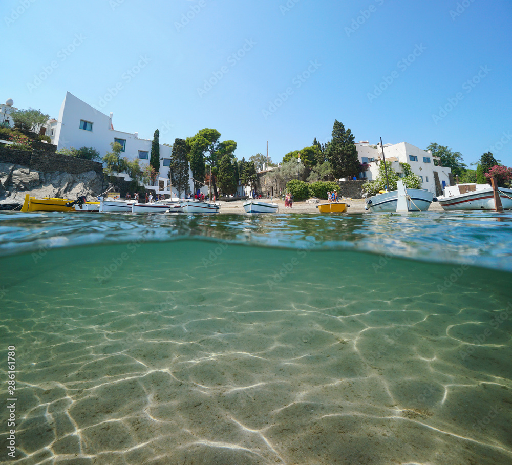 Spain Portlligat village coastline with boats and sand underwater, Mediterranean sea, split view above and below water surface, Cadaques, Costa Brava, Catalonia