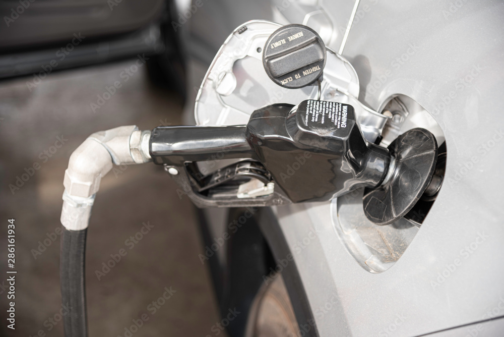 Obraz premium Filling A Vehicle’s Fuel Tank At A Gas Station