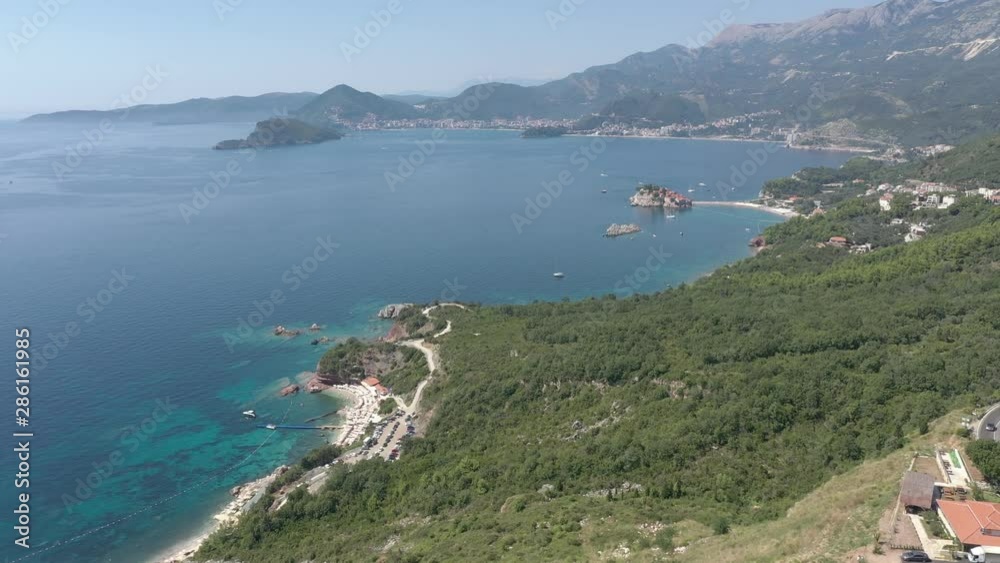 Drone flies above the coastline of the Adriatic sea, southern Montenegro, in a sunny summer day. Water in the sea is turquoise, clean and clear Drone flies above the coastline of the Adriatic sea, southern Montenegro, in a sunny summer day. Water in the sea is turquoise, clean and clear