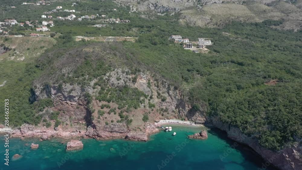 Drone flies above the coastline of the Adriatic sea, southern Montenegro, in a sunny summer day. Water in the sea is turquoise, clean and clear Drone flies above the coastline of the Adriatic sea, southern Montenegro, in a sunny summer day. Water in the sea is turquoise, clean and clear