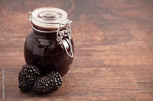 Jar of Homemade Blackberry Jam on a Rustic Wooden Table photo