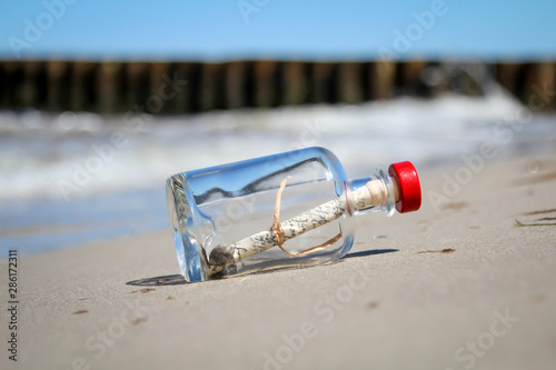 Eine angesp  lte Flaschenpost am Strand