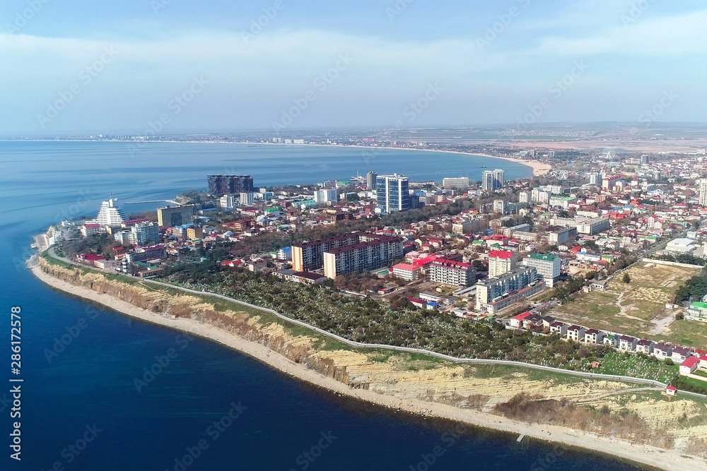 Flying over the coastal city in mountains Anapa in Russia, aerial view.