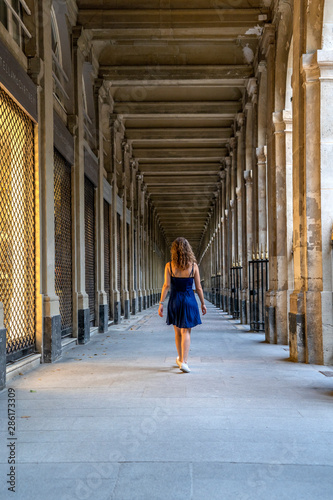 Blue dress girl in covered passage in the royal palace of Paris