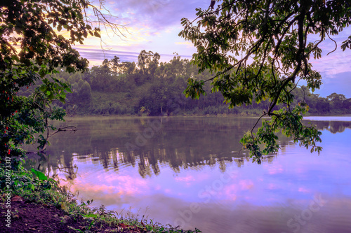 Sunrise view of Lake Nyabikere, with trees growing and the reflections on the water, Rweteera, Fort Portal, Uganda, Africa photo