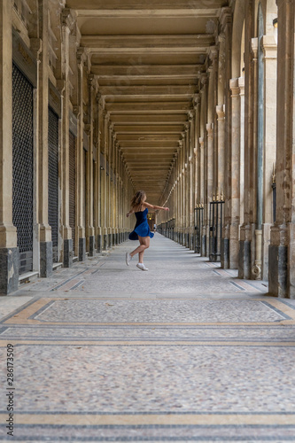 Blue dress girl in covered passage in the royal palace of Paris