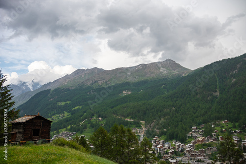 View in the mountains with old wooden barns on the mountainside meadow. Zermatt, Switzerland.