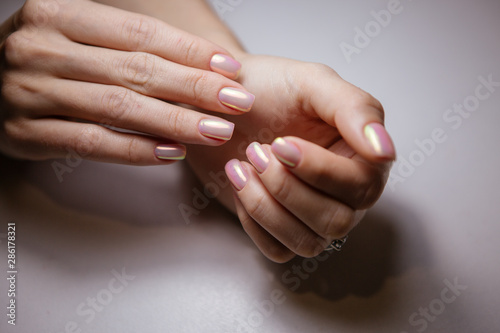 Woman in salon receiving manicure by nail beautician,manicurist uses a manicure nail file to process the nail plate and nail file