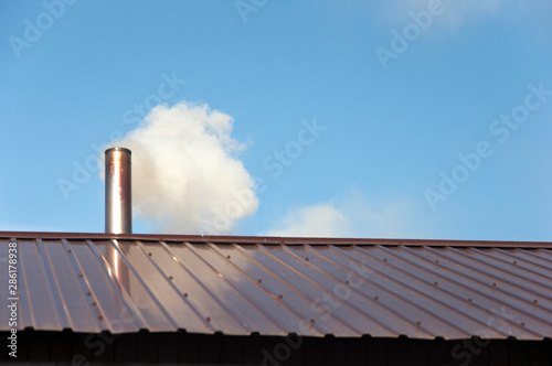 Smoke coming out the chimney against sky © vadim yerofeyev