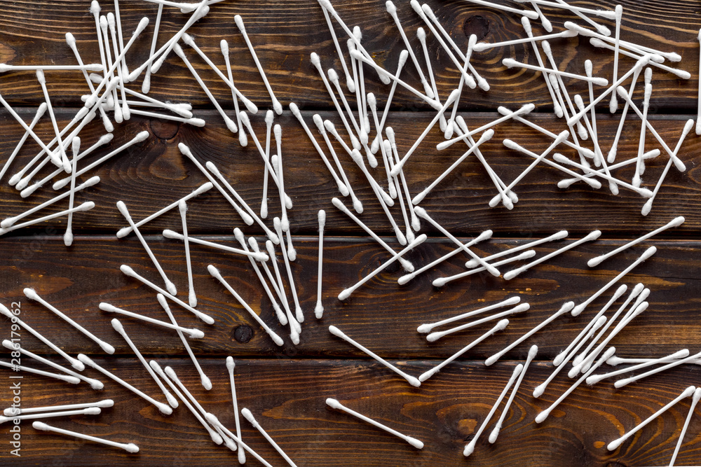 Hygiene cotton swabs pattern on wooden background top view Hygiene cotton swabs pattern on wooden background top view