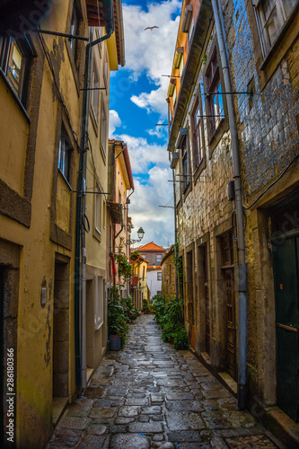 Fototapeta Naklejka Na Ścianę i Meble -  Narrow street in old town with small houses in centre, Porto
