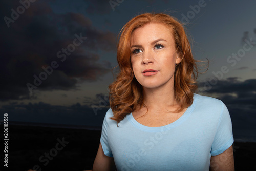 Portrait of beautiful woman with red hair at night