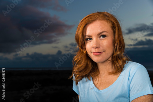 Portrait of beautiful woman with red hair at night