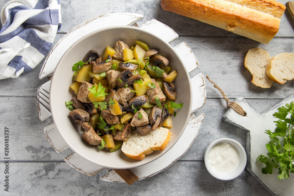 Roast meat (pork, beef) with potatoes, zucchini and mushrooms. Autumn fried stew with sour cream and parsley, traditional food, hearty tasty lunch