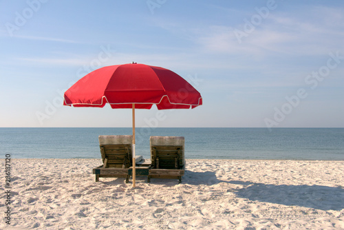 Beach Chairs with Red Umbrella on White Sandy Beach
