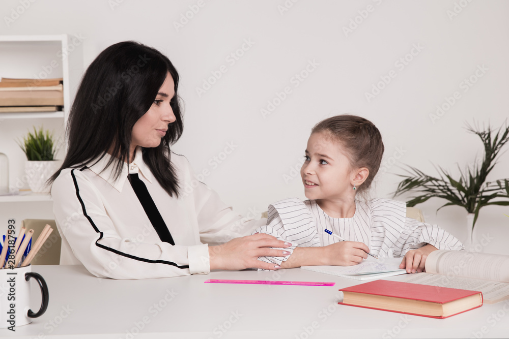 Mom with little baby girl together at home sitting at the table Mom with little baby girl together at home sitting at the table