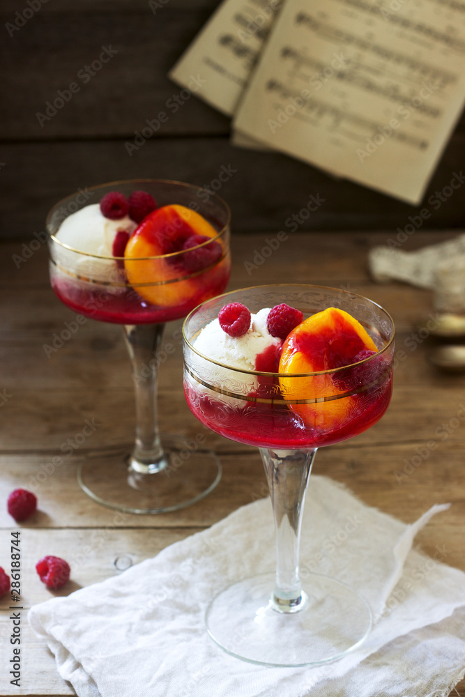 Ice cream, peach and raspberry sauce dessert dedicated to Australian opera singer Melba. Rustic style.