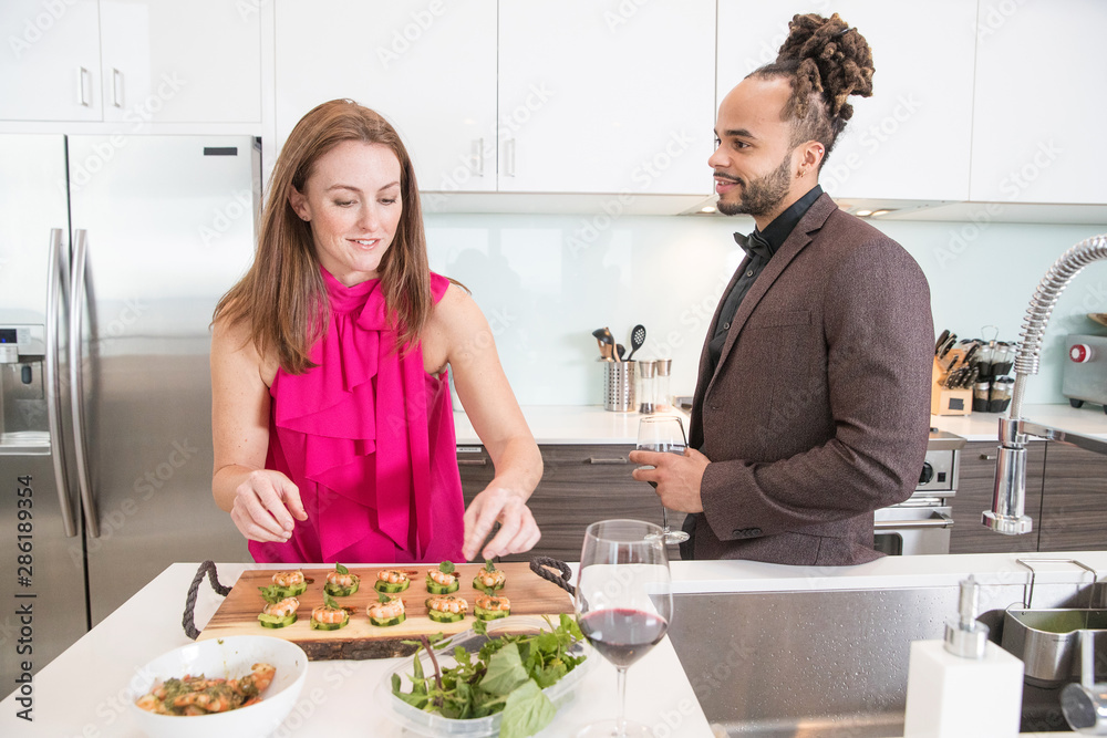 Young couple cooking together in kitchen at home Young couple cooking together in kitchen at home