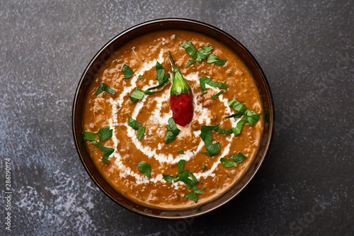 Dal Makhani at dark background. Dal Makhani - traditional indian cuisine puree dish with urad beans, red beans, butter, spices and cream. photo