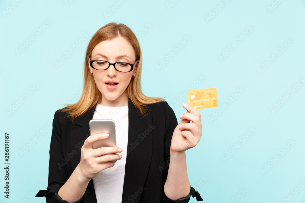 Sale concept. Woman holding credit card with phone and using it to make shopping online Sale concept. Woman holding credit card with phone and using it to make shopping online