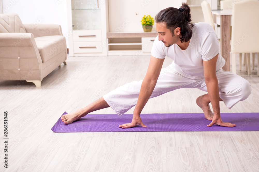 Young man doing physical exercises at home Young man doing physical exercises at home