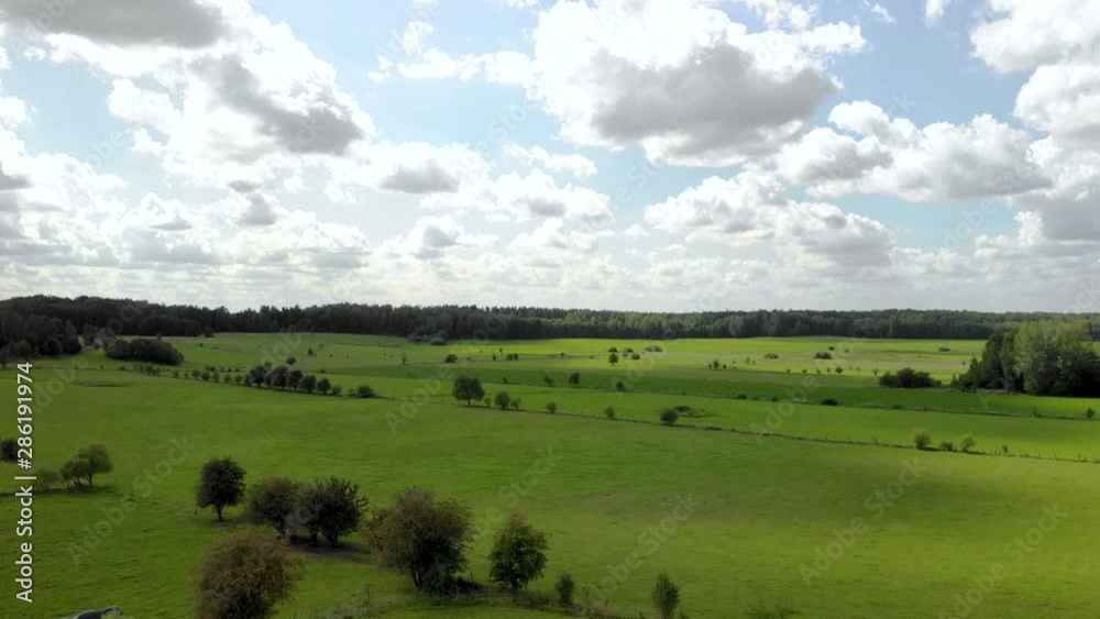 Beautiful Aerial Drone Shot Of severeal Green Fields With Farm. 4K wide shot.