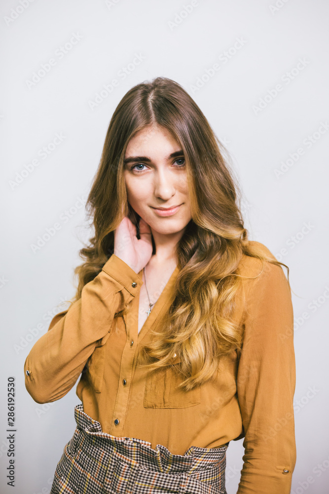Portrait of beautiful woman with curly long hair on white background. Makeup, fashion, beauty Portrait of beautiful woman with curly long hair on white background. Makeup, fashion, beauty