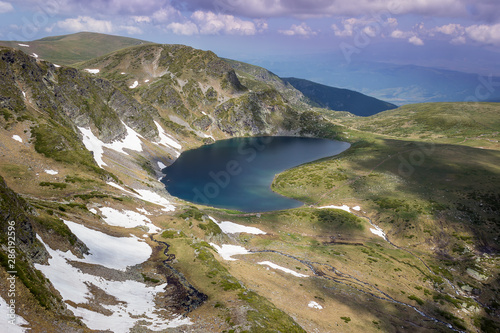 Beautiful light on a Kidney lake and Rila mountain landscape with lots of hikers, mountain tracks and impressive rocky summits viewed from lakes peak photo